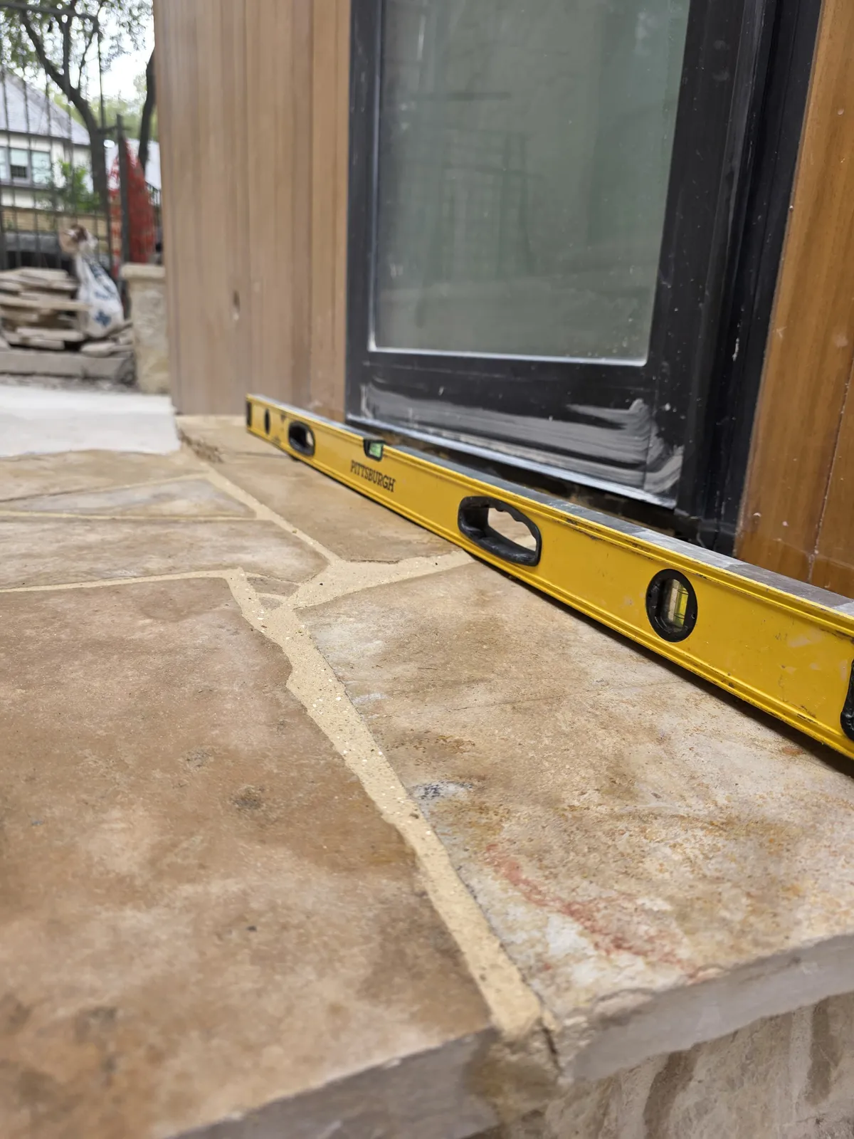 Level placed across natural flagstone during precise patio installation