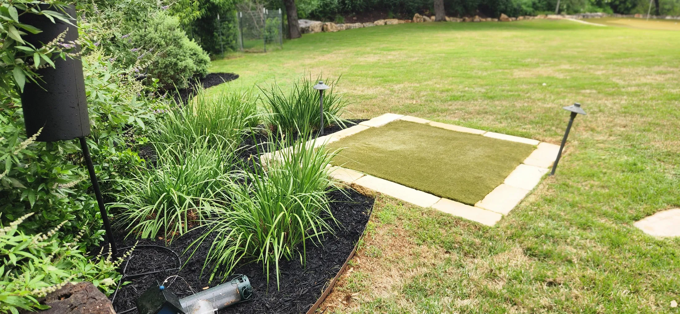 Curved planting bed meeting a green residential lawn