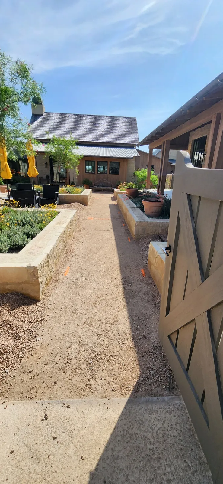 Narrow garden walkway between raised masonry beds