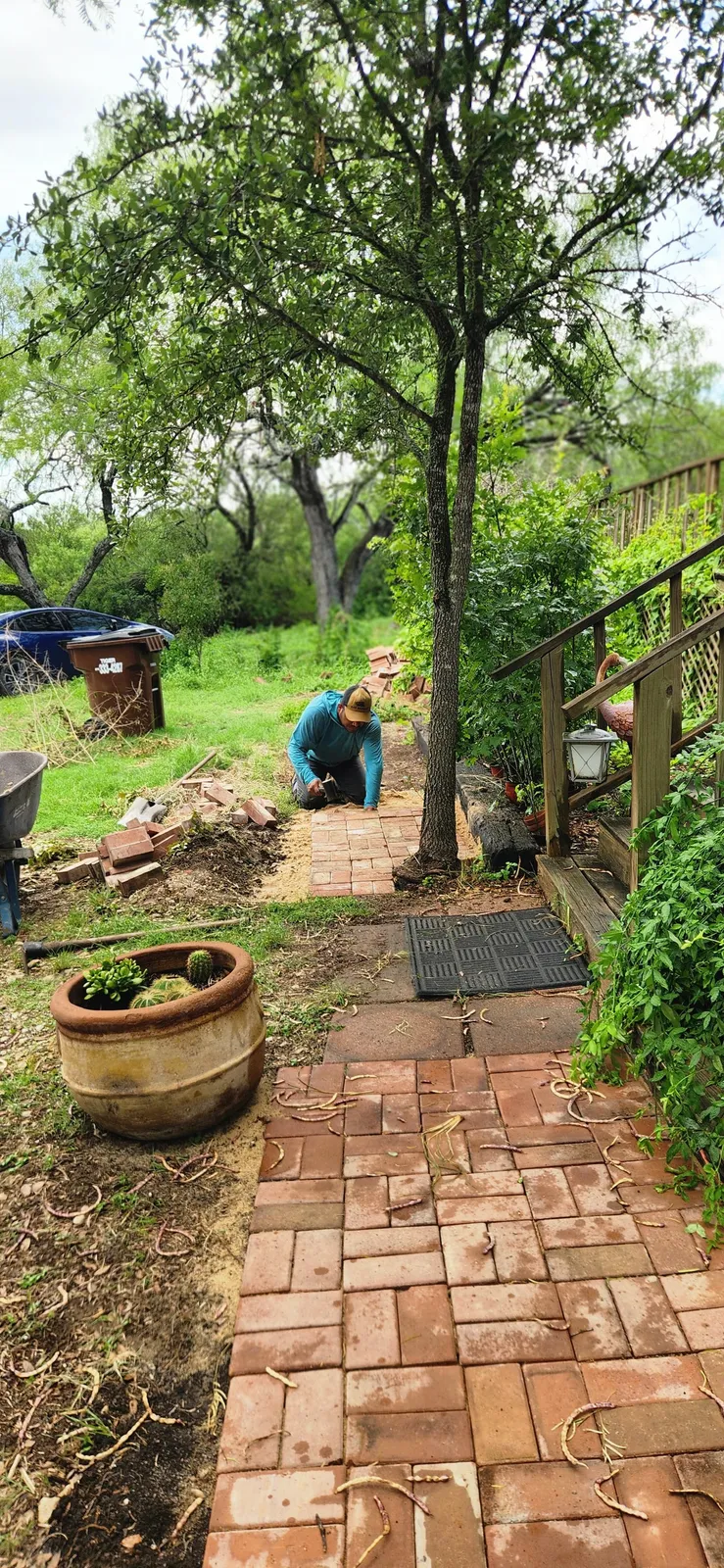 MG Landscapes team member carefully installing a brick garden path
