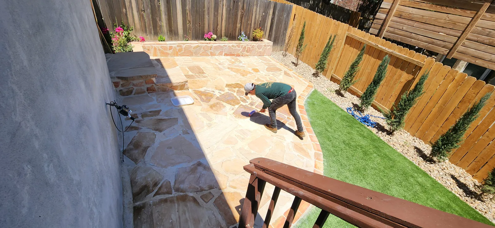 Completed flagstone patio in a fenced backyard