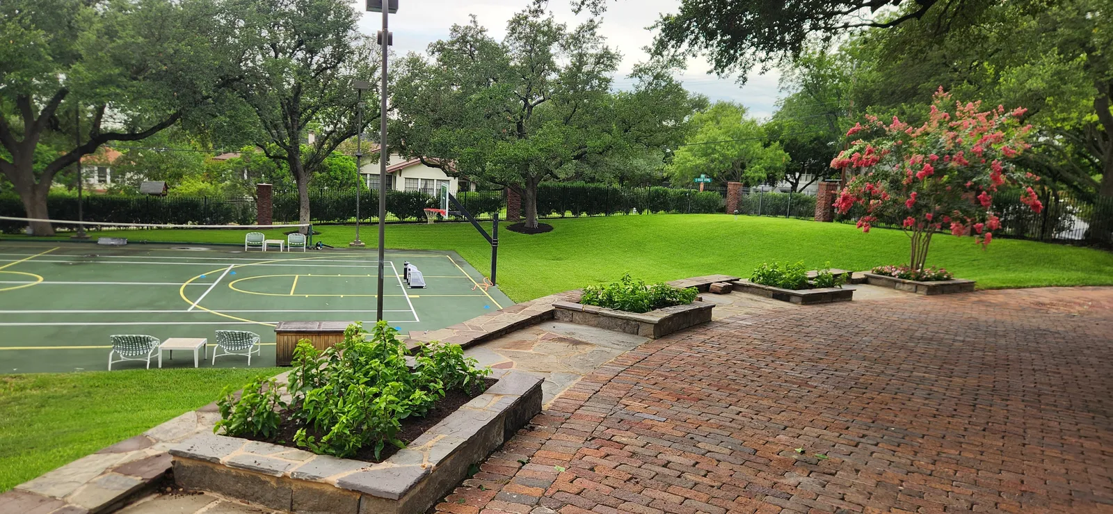 Finished landscaped terrace with brick paving and mature trees
