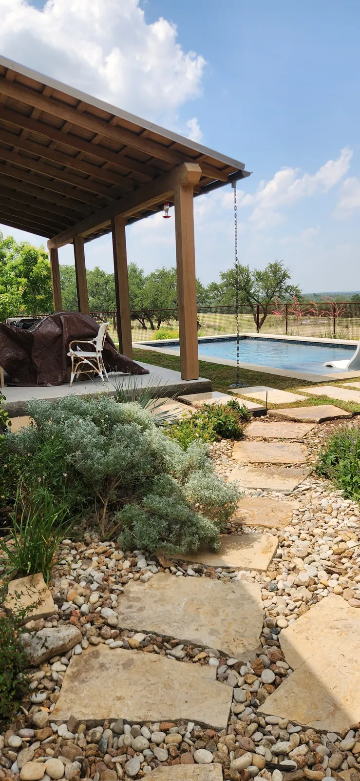 Poolside garden with stone path and soft planting