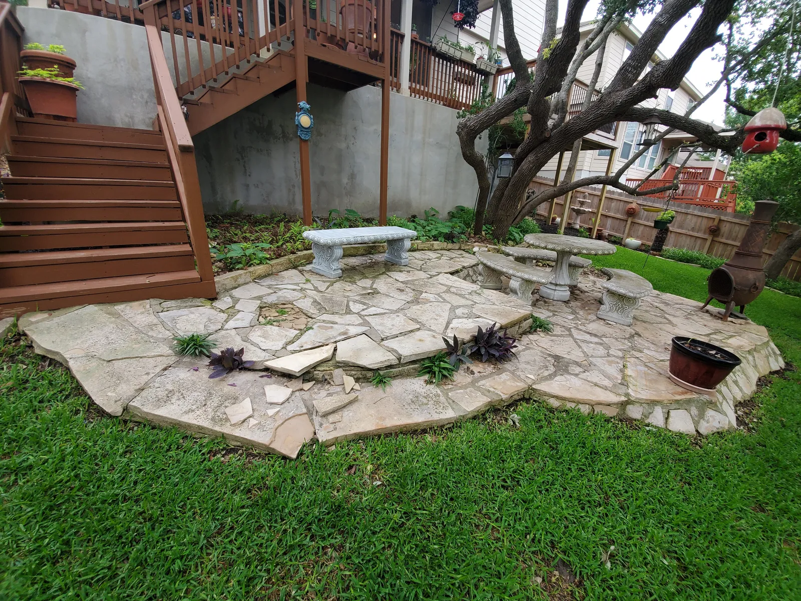 Circular backyard stone patio surrounded by lawn