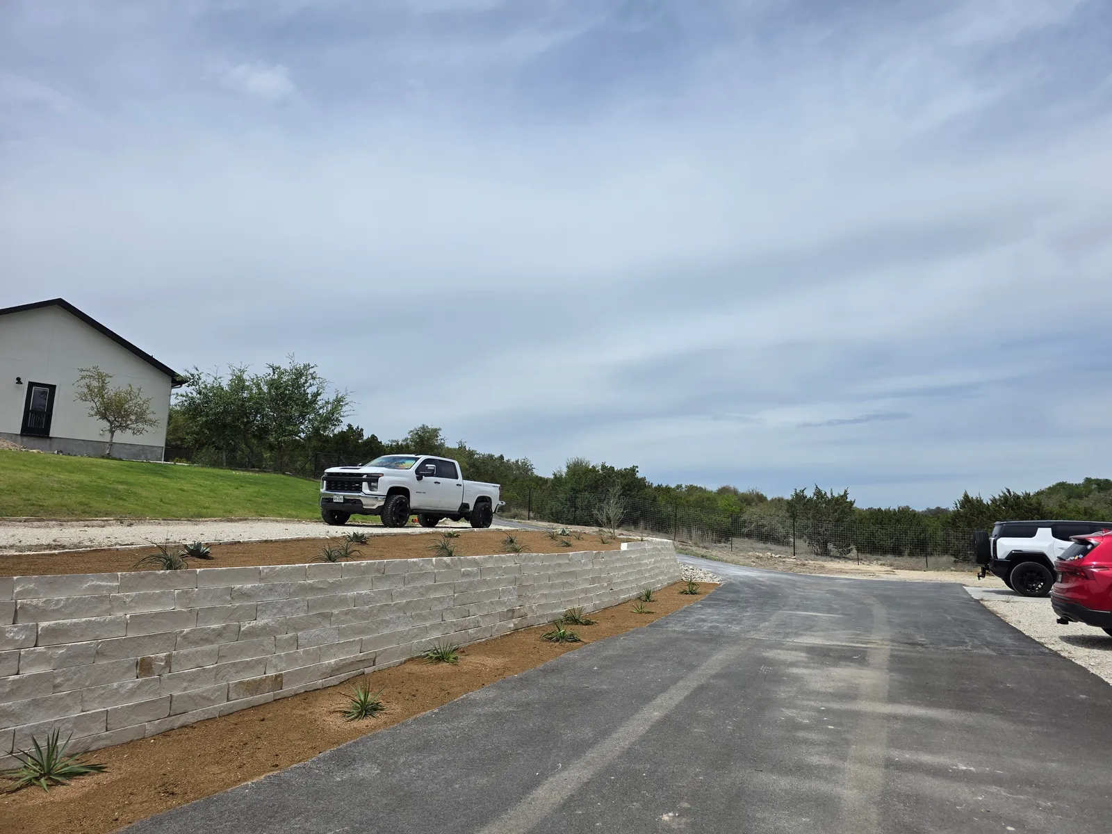 Residential site prepared for new landscape construction with work vehicles nearby