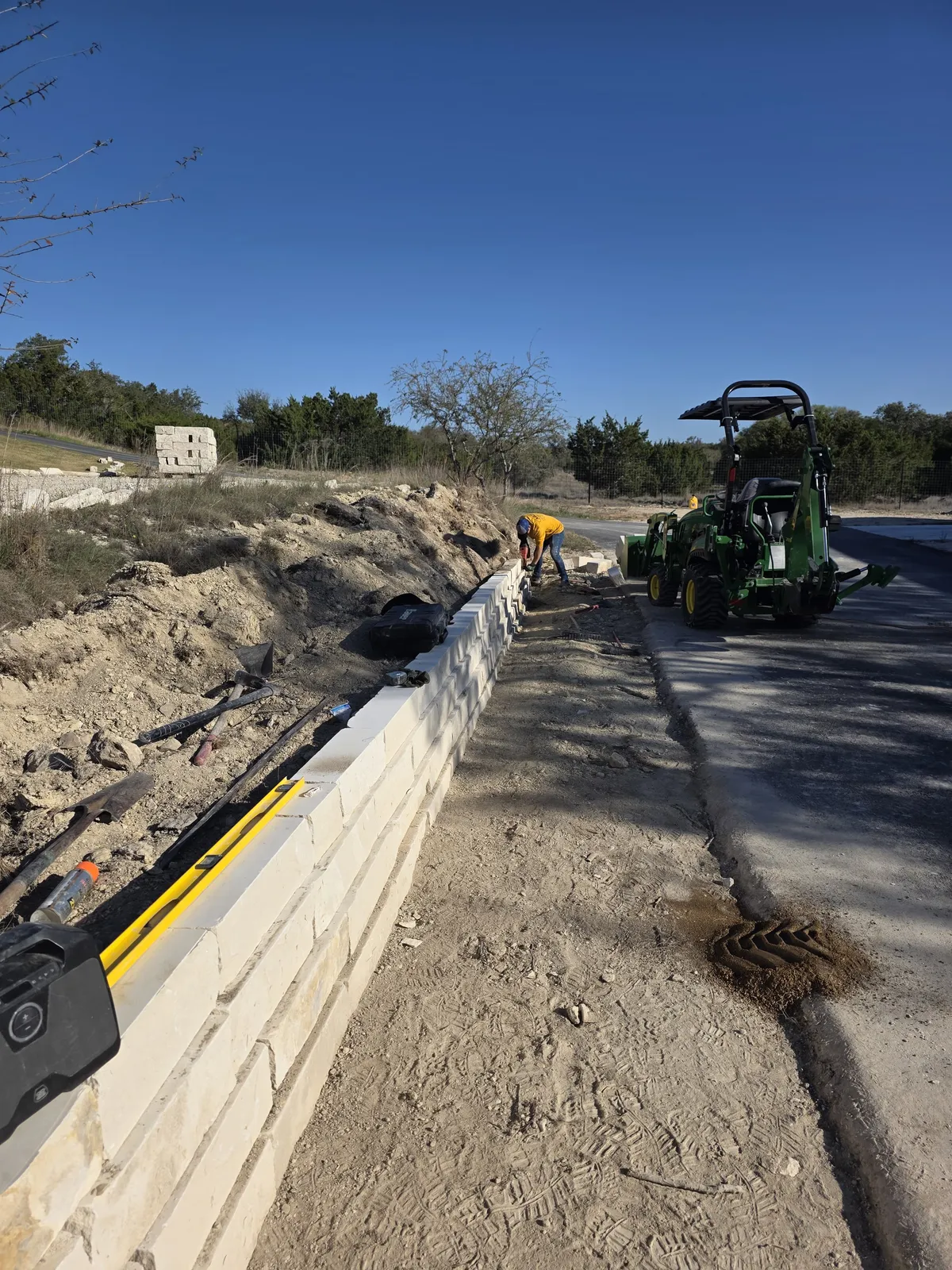 Segmental retaining wall being built along a residential drive